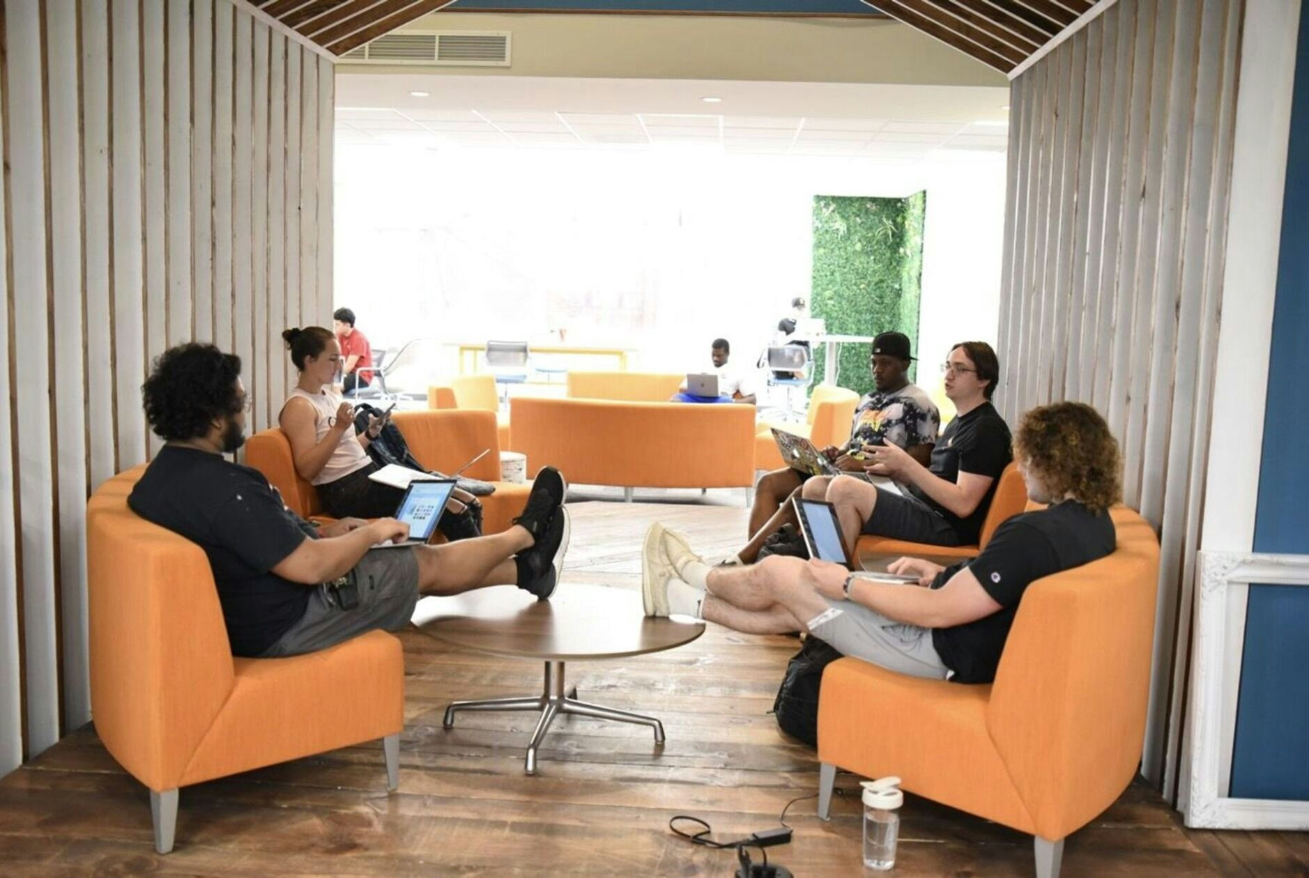 Students studying in organge chairs in the Hub